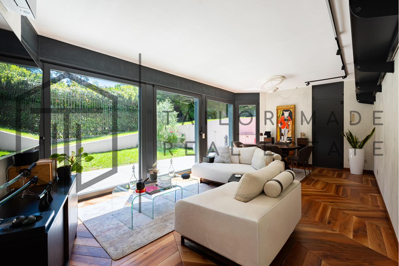Soggiorno con grande vetrata panoramica sul giardino privato