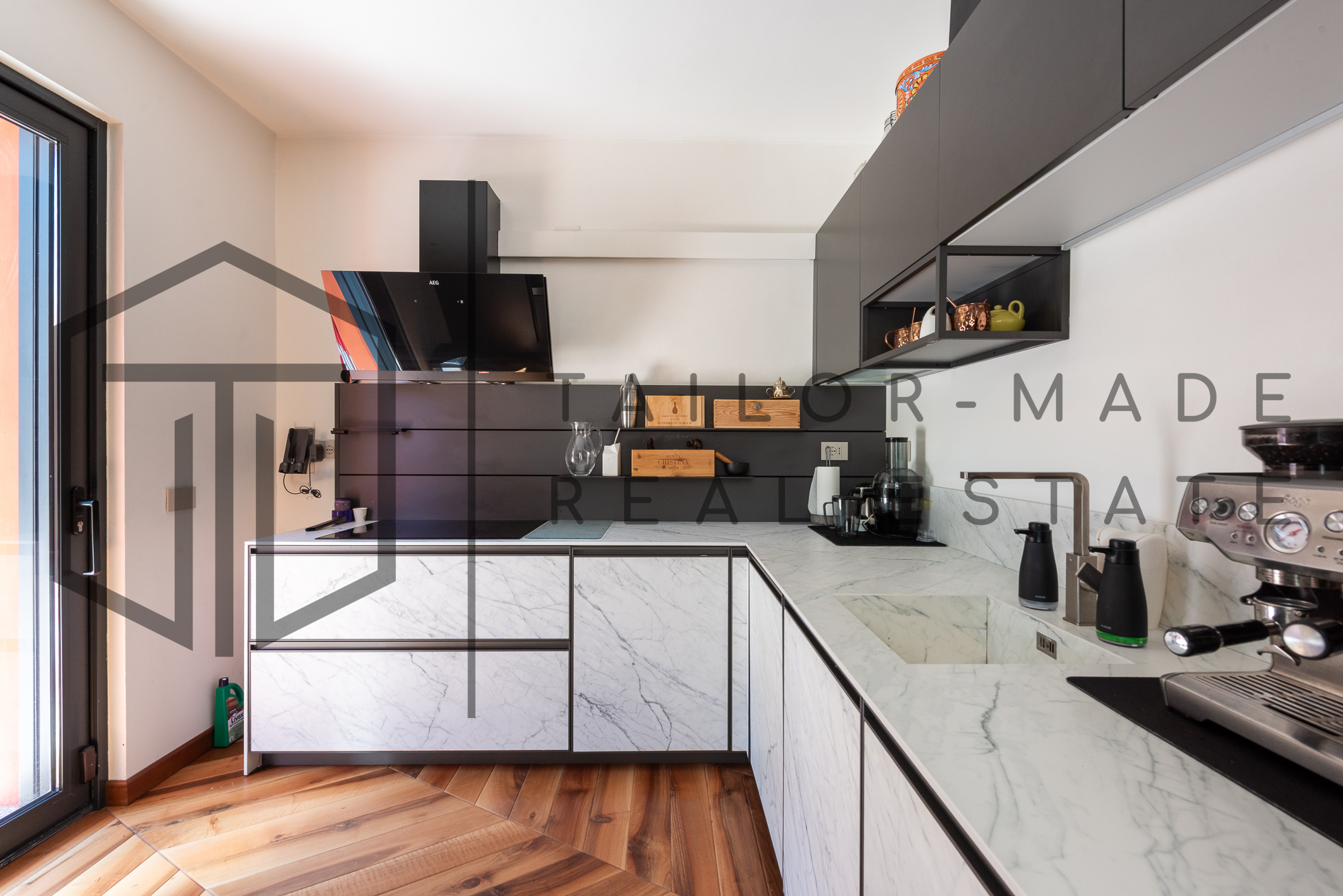 Cucina con piano in marmo bianco e elettrodomestici AEG