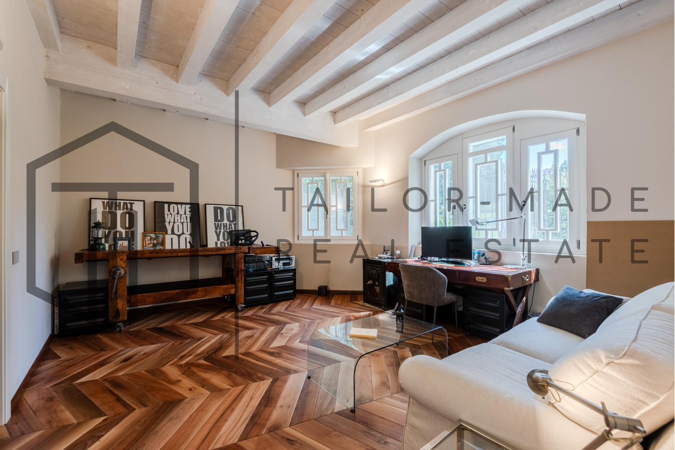 Studio con travi a vista e parquet a spina di pesce