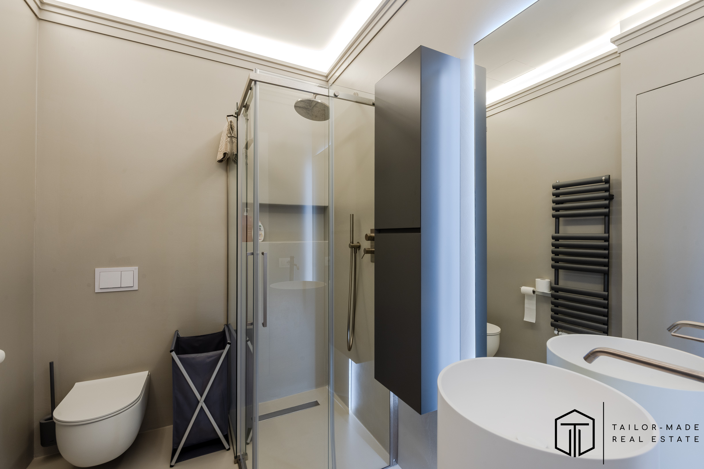 Bagno della zona giorno con zona lavanderia, finiture in resina